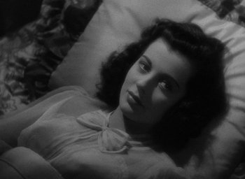 Movie still from “The Uninvited” (1944), directed by Lewis Allen – A woman laying in a bed with a pillow; Close Up shot, High angle