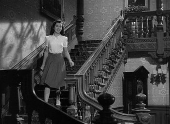 Movie still from “The Uninvited” (1944), directed by Lewis Allen – A woman walking down a set of stairs; Wide shot, Low angle
