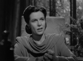 Movie still from “The Uninvited” (1944), directed by Lewis Allen – A woman sitting in a chair in front of a forest; Close Up shot, Low angle