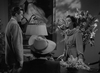 Movie still from “The Uninvited” (1944), directed by Lewis Allen – An old black and white photo of a woman talking to a man; Medium shot, Over the shoulder angle