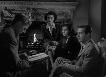 Movie still from “The Uninvited” (1944), directed by Lewis Allen – A group of people sitting in front of a fire place; Medium shot, High angle