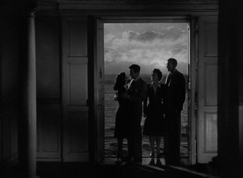 Movie still from “The Uninvited” (1944), directed by Lewis Allen – A group of people standing in front of an open door; Extreme Wide shot, Low angle