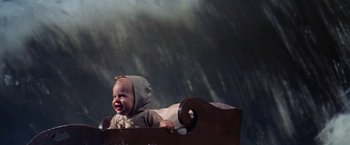 Movie still from “The Unsinkable Molly Brown” (1964), directed by Charles Walters – A baby crying in a crib in the middle of a rain storm; Medium shot, High angle
