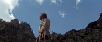 Movie still from “The Unsinkable Molly Brown” (1964), directed by Charles Walters – A man standing on top of a mountain looking up at the sky; Wide shot, Low angle
