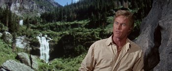 Movie still from “The Unsinkable Molly Brown” (1964), directed by Charles Walters – A person wearing a plaid shirt near a forest; Medium shot, Over the shoulder angle