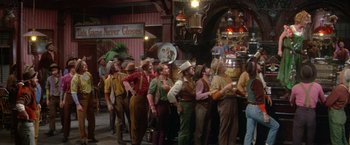 Movie still from “The Unsinkable Molly Brown” (1964), directed by Charles Walters – A group of men standing next to each other; Wide shot, Over the shoulder angle