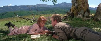 Movie still from “The Unsinkable Molly Brown” (1964), directed by Charles Walters – A man and a woman laying in the grass; Medium shot, Low angle
