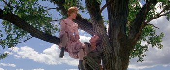 Movie still from “The Unsinkable Molly Brown” (1964), directed by Charles Walters – A man and a woman sitting on a tree; Medium shot, Low angle