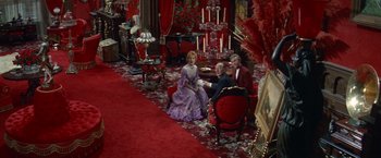Movie still from “The Unsinkable Molly Brown” (1964), directed by Charles Walters – A group of people sitting on a couch in a living room; Wide shot, High angle