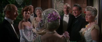 Movie still from “The Unsinkable Molly Brown” (1964), directed by Charles Walters – An older woman and a man in formal wear; Medium shot, Over the shoulder angle