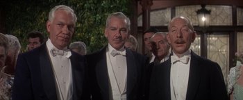 Movie still from “The Unsinkable Molly Brown” (1964), directed by Charles Walters – A group of men in tuxedos standing next to each other; Medium shot, Low angle