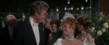 Movie still from “The Unsinkable Molly Brown” (1964), directed by Charles Walters – A man and a woman in formal wear at an event; Close Up shot, Over the shoulder angle