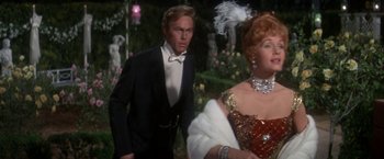 Movie still from “The Unsinkable Molly Brown” (1964), directed by Charles Walters – A man and a woman dressed in formal wear; Medium shot, Over the shoulder angle