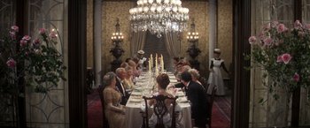 Movie still from “The Unsinkable Molly Brown” (1964), directed by Charles Walters – A group of people sitting at a dinner table; Wide shot, High angle