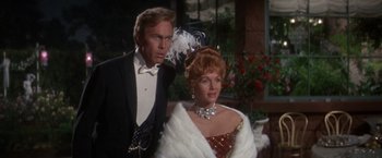 Movie still from “The Unsinkable Molly Brown” (1964), directed by Charles Walters – A man standing next to a woman wearing a dress; Medium shot, Over the shoulder angle