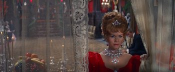 Movie still from “The Unsinkable Molly Brown” (1964), directed by Charles Walters – A wax figure of a woman in a red dress; Close Up shot, Over the shoulder angle
