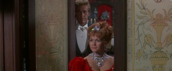 Movie still from “The Unsinkable Molly Brown” (1964), directed by Charles Walters – A man and a woman in formal wear looking in a mirror; Medium shot, Over the shoulder angle