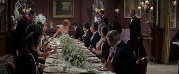 Movie still from “The Unsinkable Molly Brown” (1964), directed by Charles Walters – A group of people sitting at a long dinner table; Wide shot, High angle