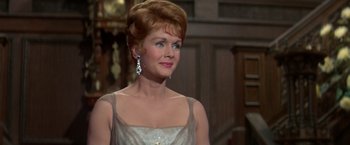 Movie still from “The Unsinkable Molly Brown” (1964), directed by Charles Walters – An older woman in a white dress and a diamond earring; Close Up shot, Over the shoulder angle