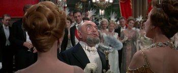 Movie still from “The Unsinkable Molly Brown” (1964), directed by Charles Walters – An old man with a beard and a mustache in front of a group of people; Medium shot, Low angle