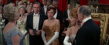 Movie still from “The Unsinkable Molly Brown” (1964), directed by Charles Walters – A group of people standing in a room; Medium shot, Over the shoulder angle