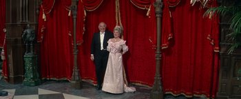 Movie still from “The Unsinkable Molly Brown” (1964), directed by Charles Walters – An older man standing next to an older woman; Wide shot, Low angle