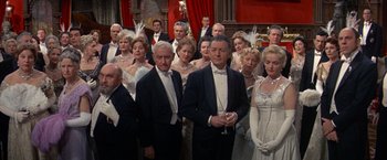 Movie still from “The Unsinkable Molly Brown” (1964), directed by Charles Walters – A group of people in formal wear standing in a room; Wide shot, High angle