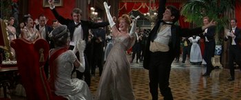 Movie still from “The Unsinkable Molly Brown” (1964), directed by Charles Walters – A group of men and women in formal wear dancing; Wide shot, Low angle