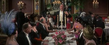 Movie still from “The Unsinkable Molly Brown” (1964), directed by Charles Walters – A group of people sitting around a table with candles; Medium shot, Over the shoulder angle