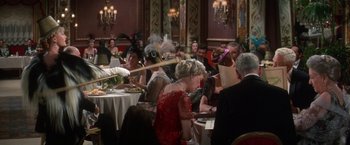 Movie still from “The Unsinkable Molly Brown” (1964), directed by Charles Walters – A group of people sitting at a table in a room; Medium shot, Over the shoulder angle