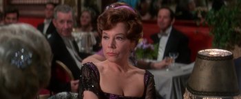 Movie still from “The Unsinkable Molly Brown” (1964), directed by Charles Walters – An older woman in a black and purple dress; Close Up shot, Over the shoulder angle