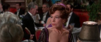 Movie still from “The Unsinkable Molly Brown” (1964), directed by Charles Walters – An older woman in a black and purple dress; Close Up shot, Over the shoulder angle