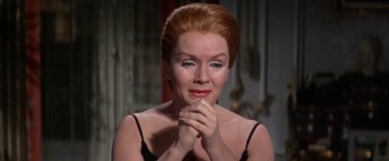 Movie still from “The Unsinkable Molly Brown” (1964), directed by Charles Walters – An older woman in a black top is holding her hands together; Close Up shot, High angle