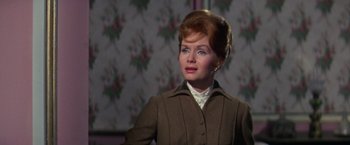 Movie still from “The Unsinkable Molly Brown” (1964), directed by Charles Walters – An older woman in a brown jacket looking to her left; Close Up shot, Over the shoulder angle