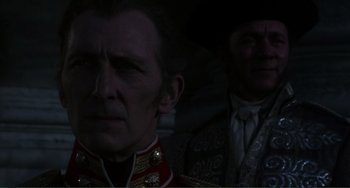 Movie still from “The Vampire Lovers” (1970), directed by Roy Ward Baker – A man in a military uniform standing next to another man in a suit; Close Up shot, Over the shoulder angle
