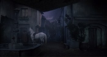Movie still from “The Vampire Lovers” (1970), directed by Roy Ward Baker – A white horse standing in the middle of an alley way; Wide shot, High angle