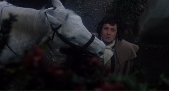 Movie still from “The Vampire Lovers” (1970), directed by Roy Ward Baker – A man and a white horse next to a bush; Medium shot, Over the shoulder angle