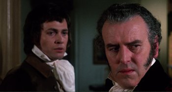 Movie still from “The Vampire Lovers” (1970), directed by Roy Ward Baker – Two men are looking at each other in a dark room; Close Up shot, Over the shoulder angle