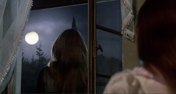 Movie still from “The Vampire Lovers” (1970), directed by Roy Ward Baker – A woman standing in front of an open window looking outside; Medium shot, Over the shoulder angle
