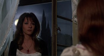 Movie still from “The Vampire Lovers” (1970), directed by Roy Ward Baker – A woman standing in front of a mirror in front of a window; Close Up shot, Over the shoulder angle