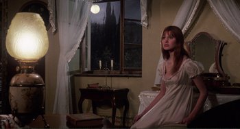 Movie still from “The Vampire Lovers” (1970), directed by Roy Ward Baker – A woman sitting in front of a window in a room; Medium shot, High angle