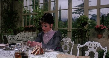 Movie still from “The Vampire Lovers” (1970), directed by Roy Ward Baker – A woman sitting at a table with a plate in front of her; Medium shot, High angle