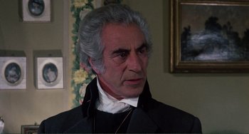 Movie still from “The Vampire Lovers” (1970), directed by Roy Ward Baker – An older man with grey hair wearing a black jacket; Close Up shot, Over the shoulder angle