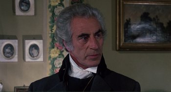 Movie still from “The Vampire Lovers” (1970), directed by Roy Ward Baker – An older man in a black jacket and white shirt; Close Up shot, Over the shoulder angle