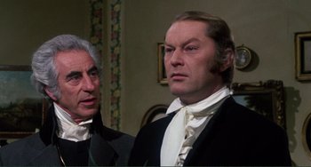 Movie still from “The Vampire Lovers” (1970), directed by Roy Ward Baker – A man in a suit and tie next to another man in a suit and tie; Close Up shot, Over the shoulder angle