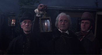 Movie still from “The Vampire Lovers” (1970), directed by Roy Ward Baker – Two men holding up a lantern with a lit candle in it; Medium shot, Low angle