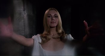Movie still from “The Vampire Lovers” (1970), directed by Roy Ward Baker – A woman with long blonde hair wearing a white shirt; Medium shot, Low angle
