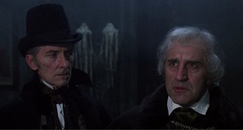 Movie still from “The Vampire Lovers” (1970), directed by Roy Ward Baker – Two older men in a dark room with a dark background; Close Up shot, Over the shoulder angle