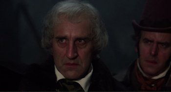Movie still from “The Vampire Lovers” (1970), directed by Roy Ward Baker – An old man with a white hair and a green tie; Close Up shot, Over the shoulder angle