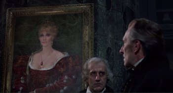 Movie still from “The Vampire Lovers” (1970), directed by Roy Ward Baker – Two men standing in front of a painting of a woman; Medium shot, Over the shoulder angle